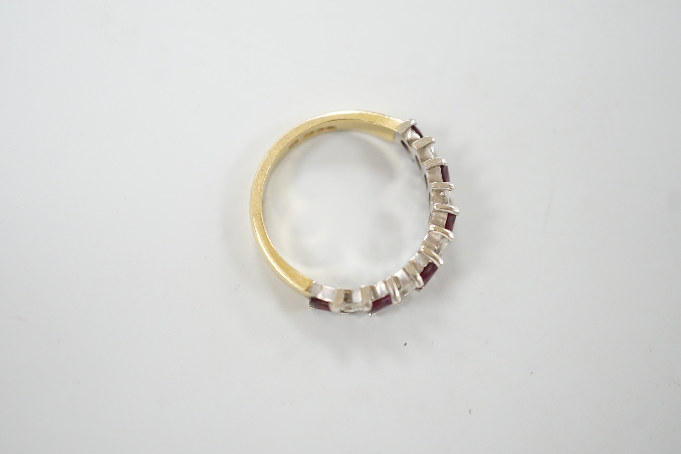 A modern 18ct gold and eleven stone marquise cut ruby and diamond set half hoop ring, size L, gross weight 3.5 grams.